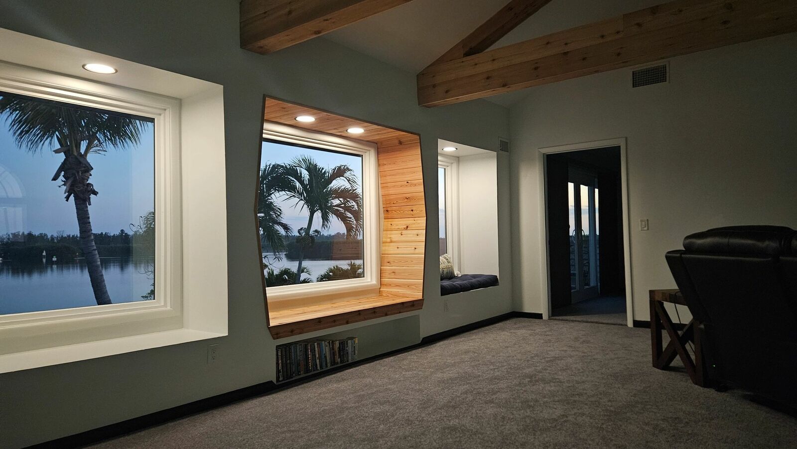 A living room with new picture windows looking out on the water