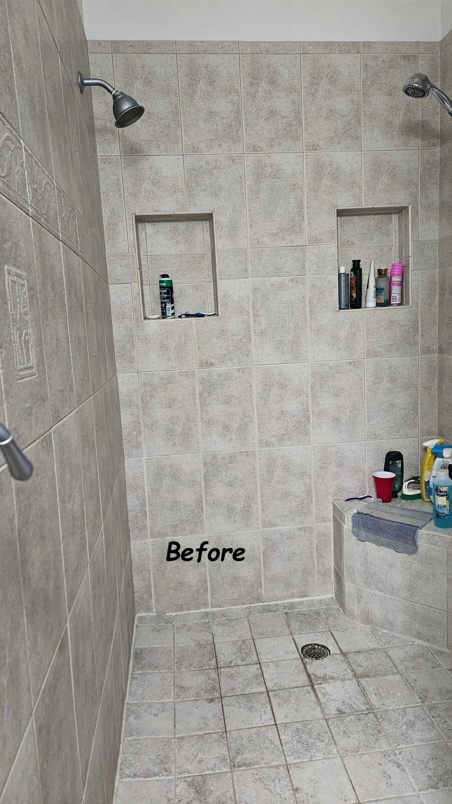 The old shower before: small beige tile and a builder-grade niche
